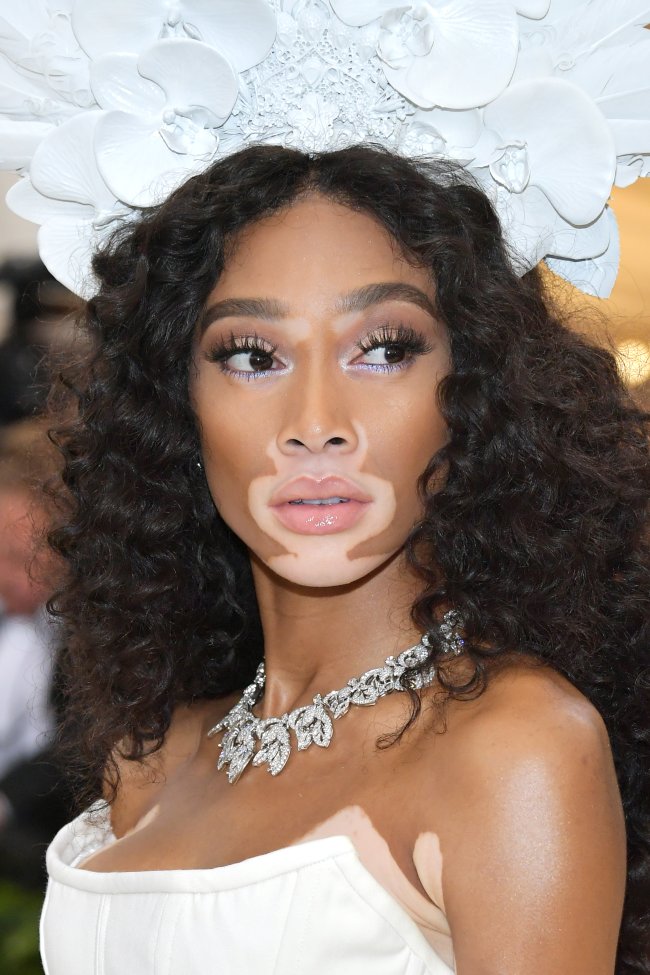 Winnie Harlow posando no MET Gala com vestido e chapéu branco