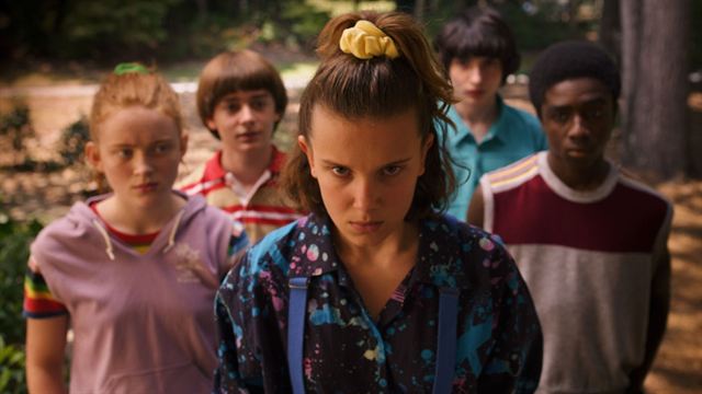 Imagem das crianças de Stranger Things; Eleven está no centro da cena olhando para câmera com uma expressão de raiva cercada por Max. Will, Mike e Lucas, que estão em segundo plano fazendo expressões de sérias e de raiva também