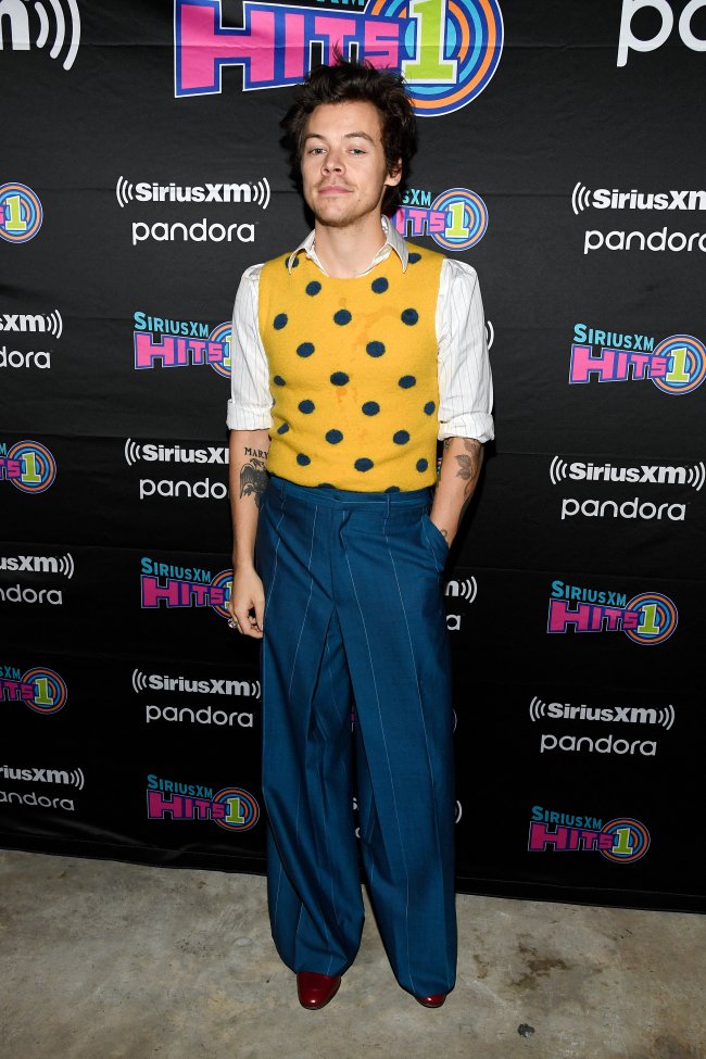 Harry Styles Harry Styles usando colete amarelo de poá por cima de uma camisa branca