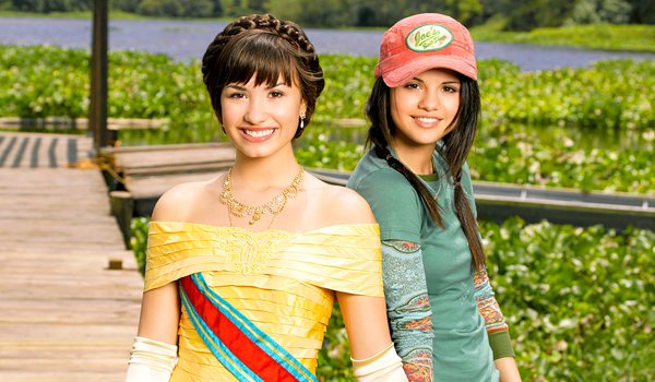 Demi Lovato e Selena Gomez sorrindo em imagem do filme Programa de Proteção Para Princesas