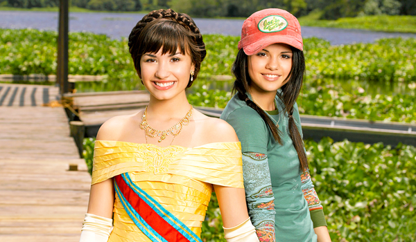 programa-proteçao-princesas Demi Lovato e Selena Gomez sorrindo em imagem do filme Programa de Proteção Para Princesas
