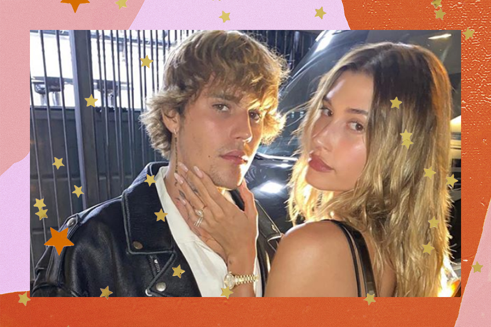 Justin e Hailey Bieber posando para foto; eles olham para a câmera com expressões sérias e Hailey está com uma das mãos no queixo do cantor; a margem é uma textura em tons de rosa, laranja e vermelho com estrelas amarelas como decoração