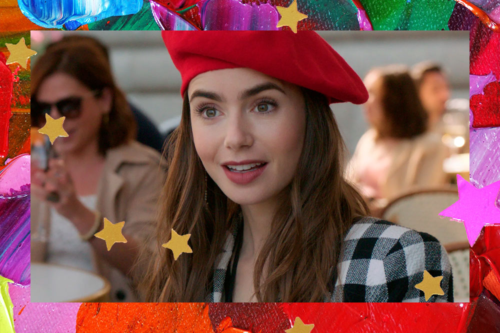 Lily Collins em cena caracterizada como Emily de "Emily em Paris"; a atriz faz cara de surpresa e usa uma boina vermelha e um blazer xadrez preto,, branco e cinza