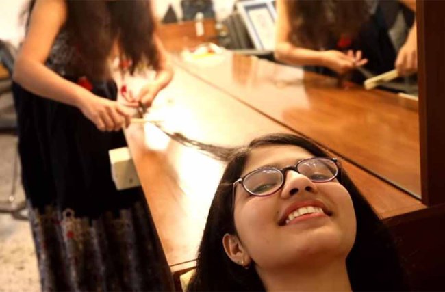 Nilanshi-Patel-medindo seu cabelo recorde guinness book 2018 Nilanshi Patel, adolescente com o cabelo mais longo do mundo, mostrando os fios