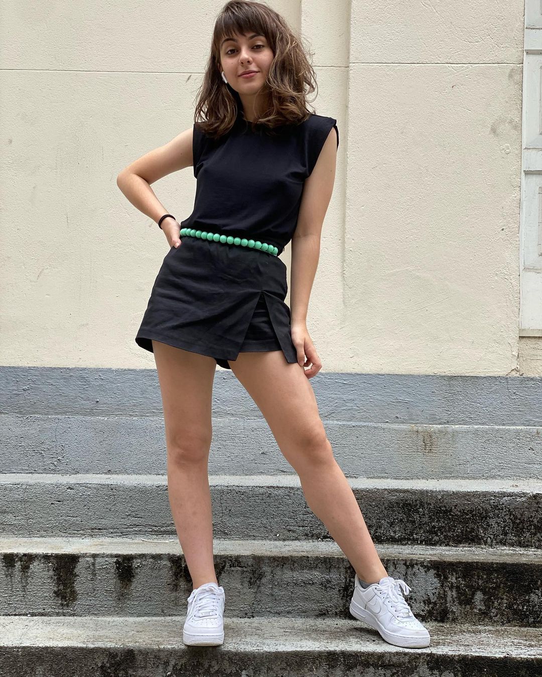look-do-dia-muscle-tee-klarafgcastanho Klara Castanho usando muscle tee preta com short saia preto, tênis branco e cinto verde