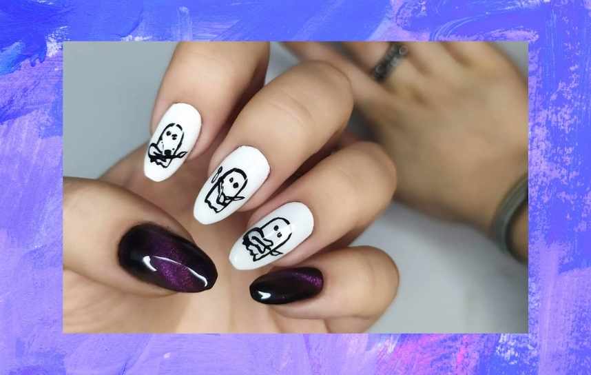 nail art com duas unhas pintadas em roxo e preto e outras três com desenhos pretos de fantasmas em fundo branco