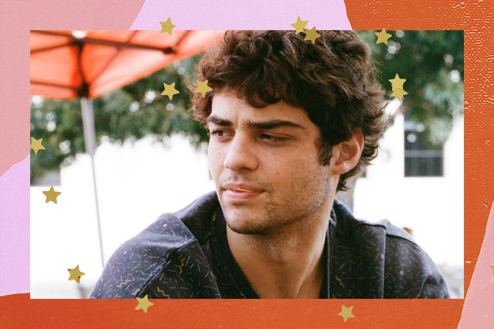 Noah Centineo olhando para o lado com expressão séria; o ator usa uma blusa preta