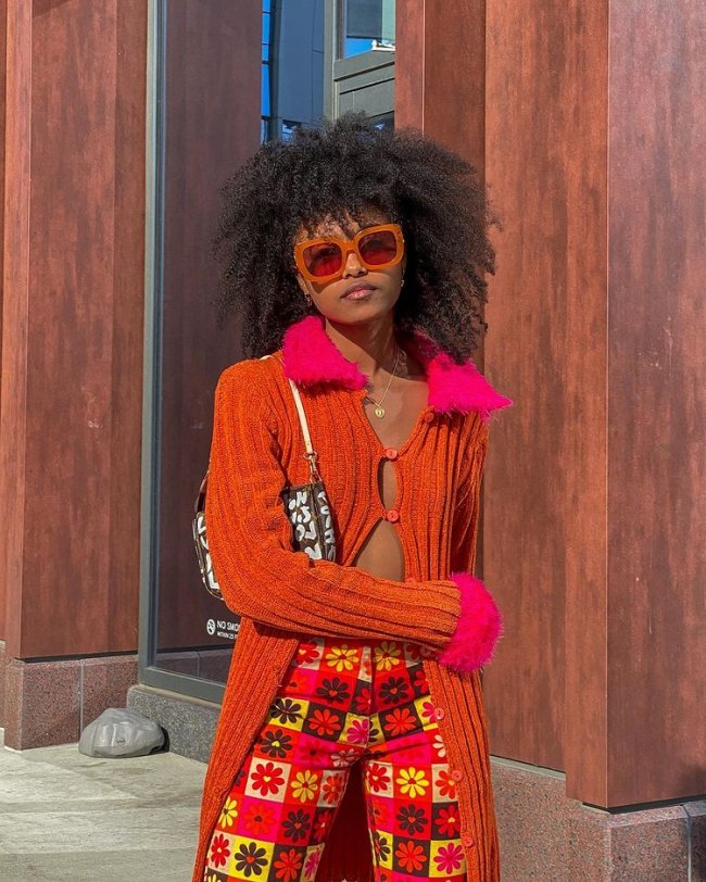 tendencia-polemica-recortes-isthisfate Garota usando cardigã laranja com gola pulsos rosa. A peça tem apenas dois botões na região dos seios