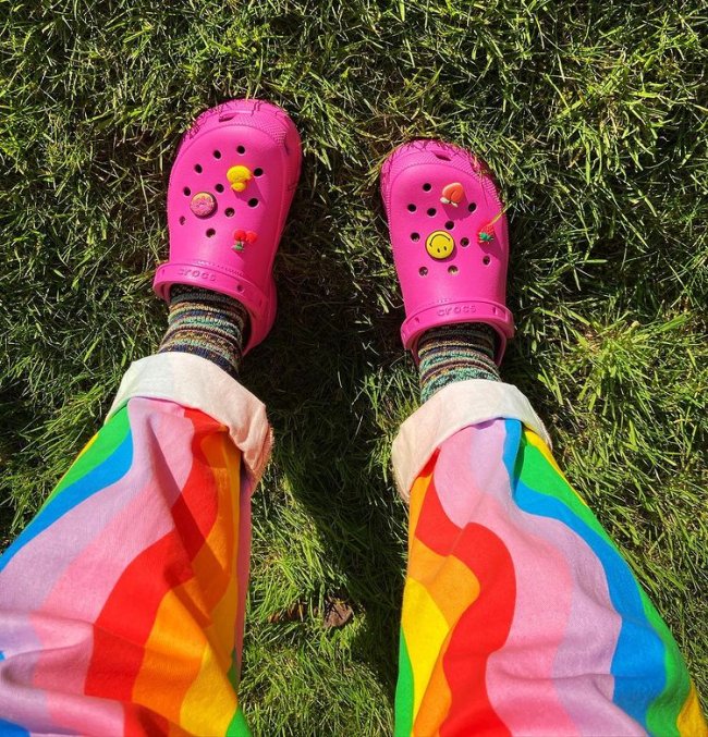 Crocs cor de rosa Foto mostrando somente parte da calça colorida com crocs rosa com pingente colorido de smile e frutas