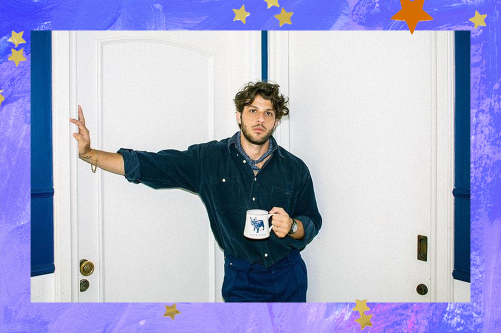 Chay Suede bebendo um café e vestido com um look total jeans