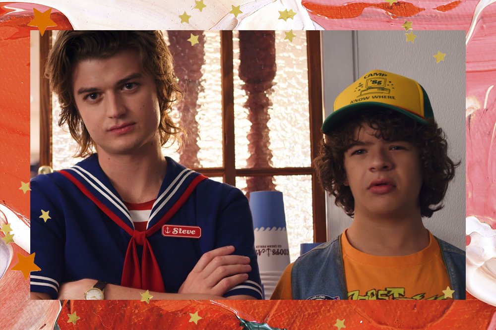 Steve e Dustin, de Stranger Things, um ao lado do outro. Steve com os braços cruzados e Dustin com expressão confusa