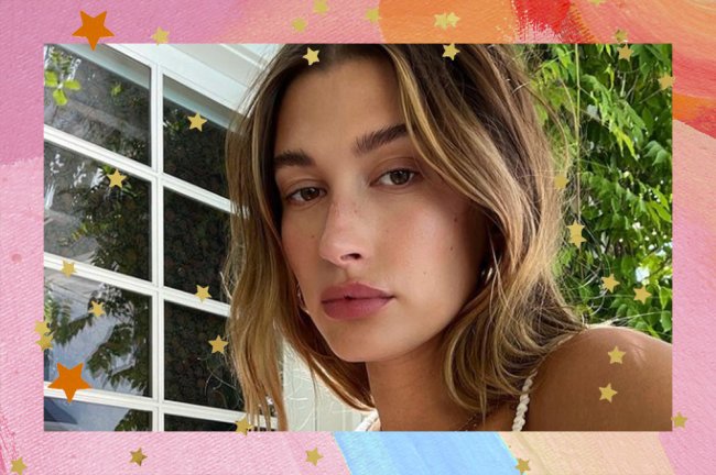 Hailey Bieber em frente a uma árvore e uma janela