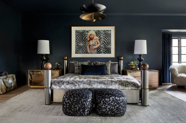 miley9 Quarto de Miley Cyrus. Na imagem, aparece uma cama de aço inoxidável, um quadro com a imagem de Debbie Harry e uma luminária em cada canto da cama. As cores que predominam a imagem são cinza, preto e azul marinho.