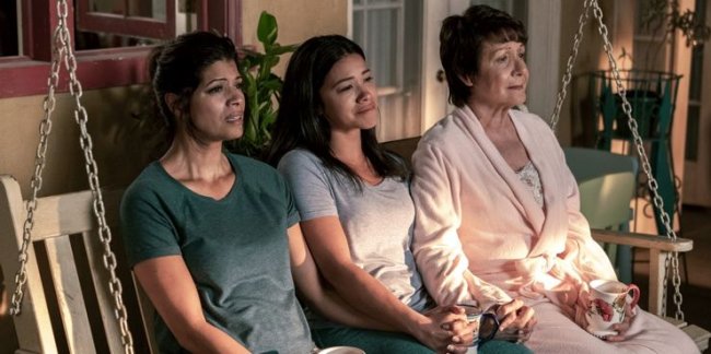 Três personagens femininas de Jane The Virgin sentadas de frente para uma luz emocionadas.