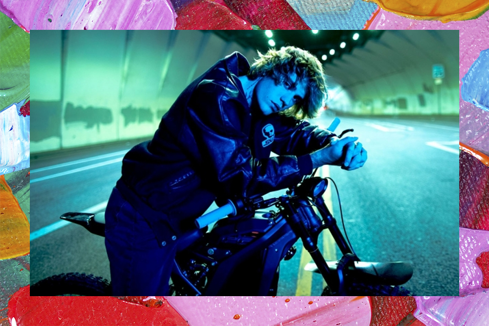Justin Bieber sentado em uma moto estacionada em um túnel