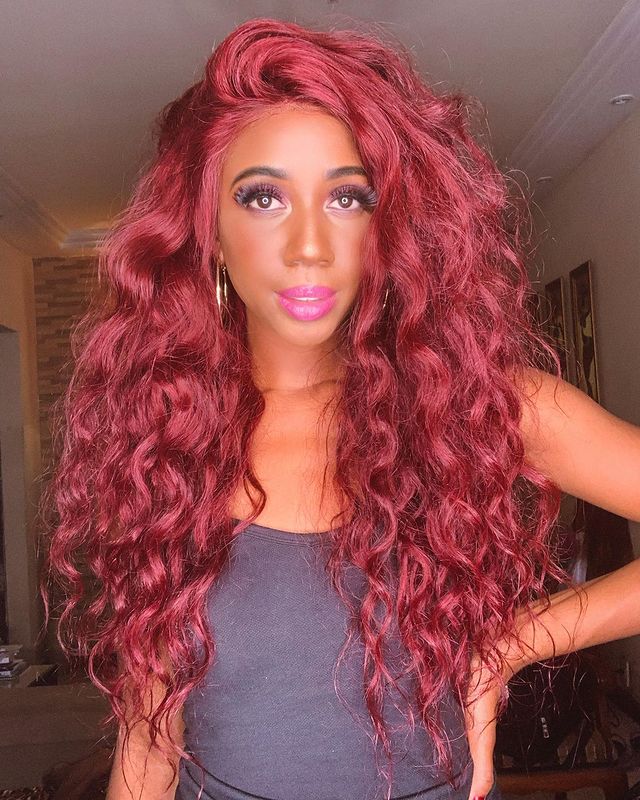 camilla de lucas com cabelo vermelho Camilla de Lucas posando com tomara que caia cinza, lace de cabelo ruiva e posando com uma das mãos apoiada na cintura. Ela está com uma expressão levemente sorridente.