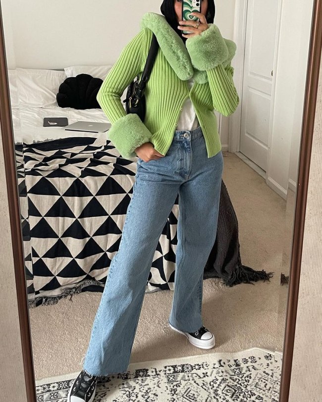 look com casaco avant basic Selfie no espelho de uma mulher. Ela usa um casaco verde menta de pelinhos, calça jeans reta, tênis preto com branco e bolsa preta. O rosto dela não aparece na foto.