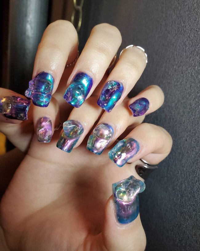 nail art azul com jelly Foto com foco nas unhas de duas mãos, com gel e azul claro e escuro. Com glitter.