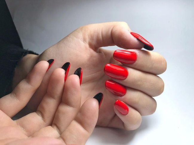 nail art flipside com vermelho e preto Foto com destaque para as mãos, unha flipside vermelha com interior preta.