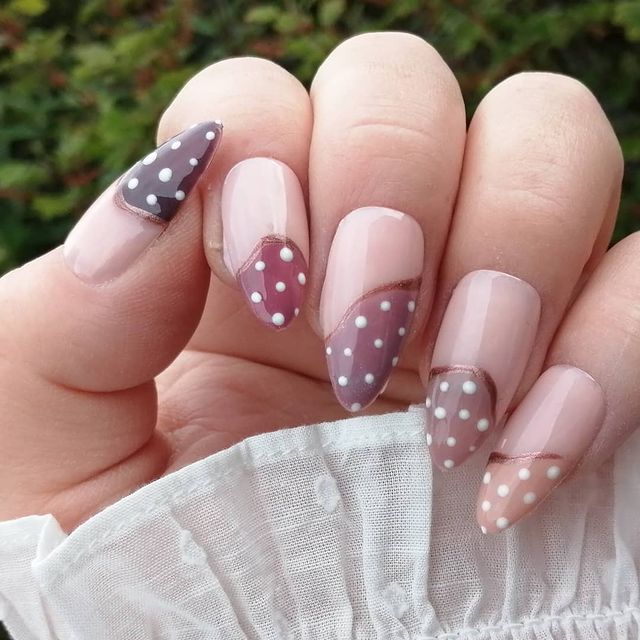 Foto com destaque nas unhas com nail art de bolinha, dessa vez com fundo bege e na pontinha detalhe marrom com bolinhas brancas.