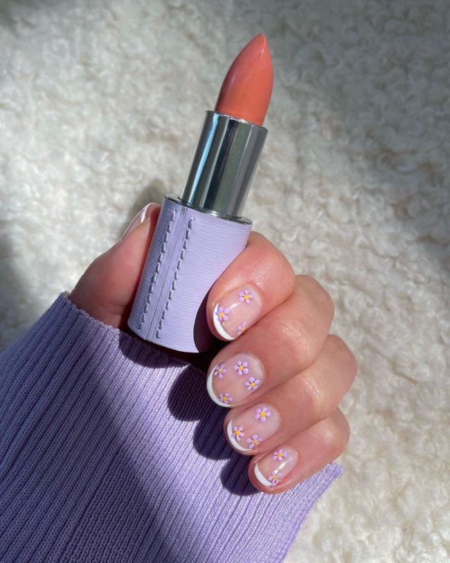 florzinha em nail art Foto com close nas unhas e tem nail art com francesinha branca e florzinha.