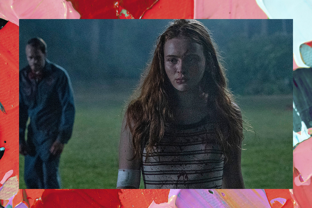 Sadie Sink em Rua do Medo 2, com um homem ensaguentado atrás. Eles estão em um campo