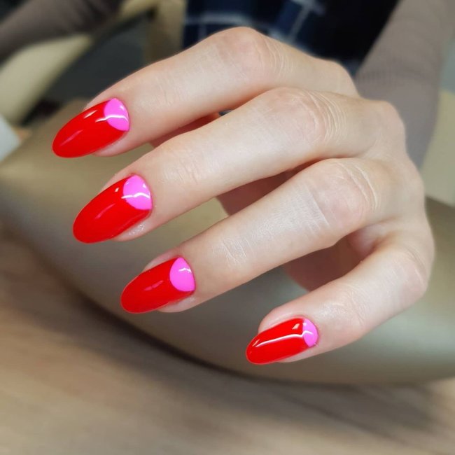 unha rosa e vermelha Foto com foco nas mãos mostrando nail art rosa com detalhes vermelhos.