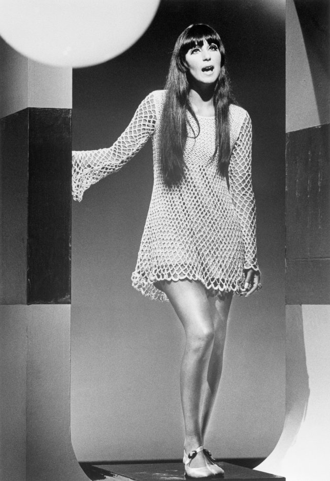 Cher Singing During TV Guest Appearance Cher posando com vestido e expressão séria.