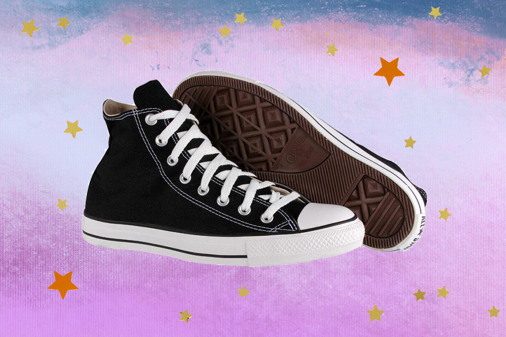 Montagem do tênis Chuck Taylor All Star preto e branco em fundo degradê de lilás e azul com estrelas douradas e laranjas