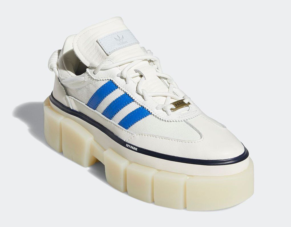 Tênis Super Sleek Chunky da coleção Adidas x IVY Park Rodeo. Ele é branco, com sola tratorada e listras azuis nas laterais.