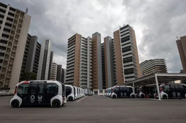 Carros elétricos estacionados em frente a prédios, em Tóquio