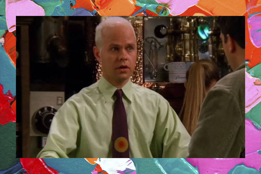 Foto de James Michael Tyler como Gunther. Nela, ele aparece com uma blusa social verde e gravata com detalhe em amarelo.