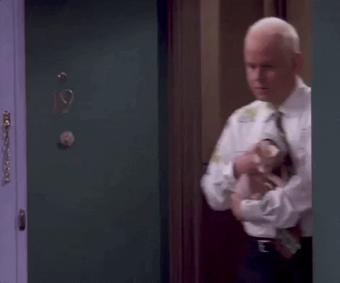 gunther Gif do personagem Gunther de Friends. Nele, ele está com uma blusa branca com detalhes verdes e um gato sem pelo no colo.