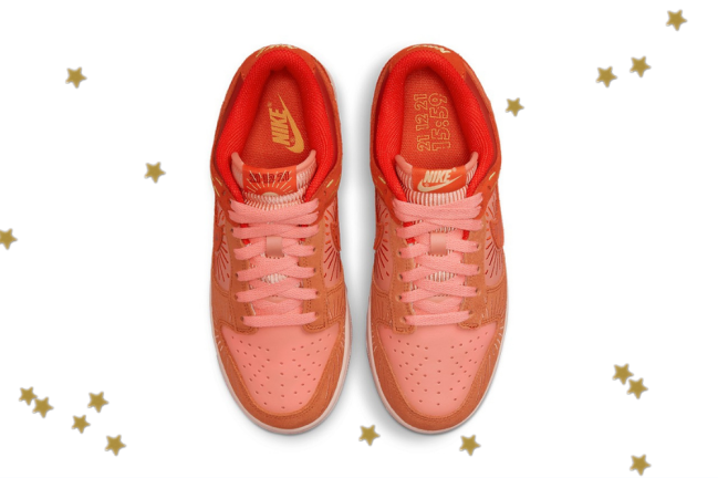 novo dunk low nike Foto com fundo branco e com estrelinhas douradas. No centro, temos o novo tênis da Nike do modelo Dunk Low com as cores laranja, vermelho e detalhes em amarelo.