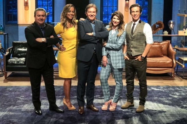 Foto de divulgação do programa Shark Tank. Nela, aparecem cinco pessoas com roupas formais posando para a foto.