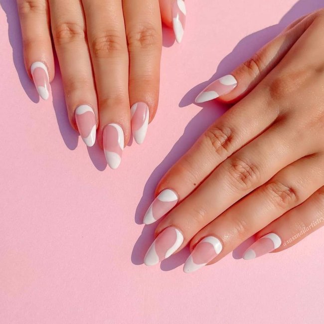 Foto com destaque nos dedos com as unhas com traços branco.