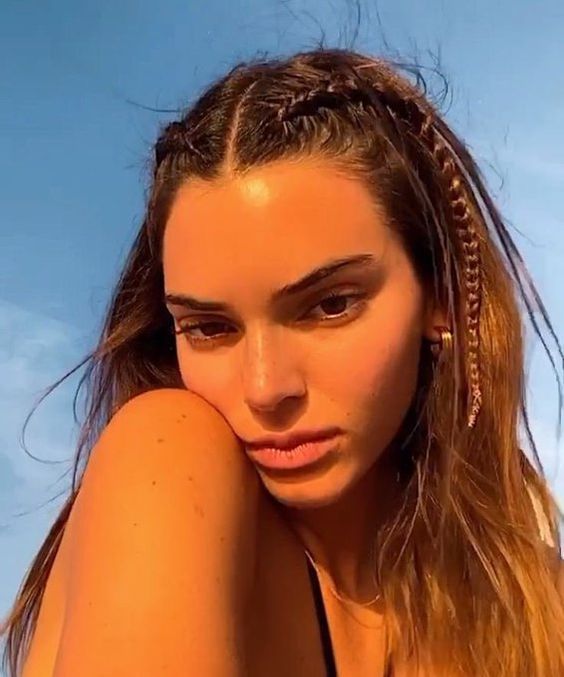 Selfie da Kendall Jenner. Ela usa um biquíni preto, cabelo solto com trança nas laterais do cabelo. Ela olha para a câmera e não sorri.