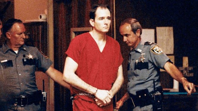 Você sabia que a franquia “Pânico” é inspirada em uma história real? Foto do serial Killer Danny Rolling. Ele está algemado, com uma roupa vermelha e cercado por policias no tribunal