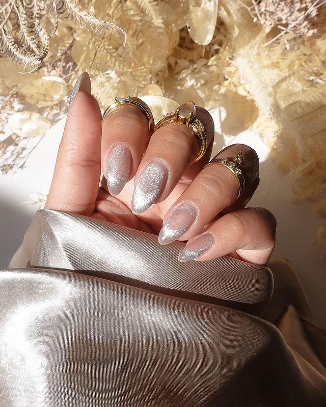 efeito-unhas-aveludadas Foto de uma mão com as unhas longas e nail art com efeito aveludado com esmalte metalizado.
