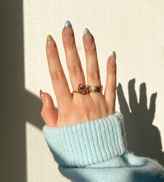 Foto de uma mão com as unhas longas com francesinhas coloridas com esmalte magnético.