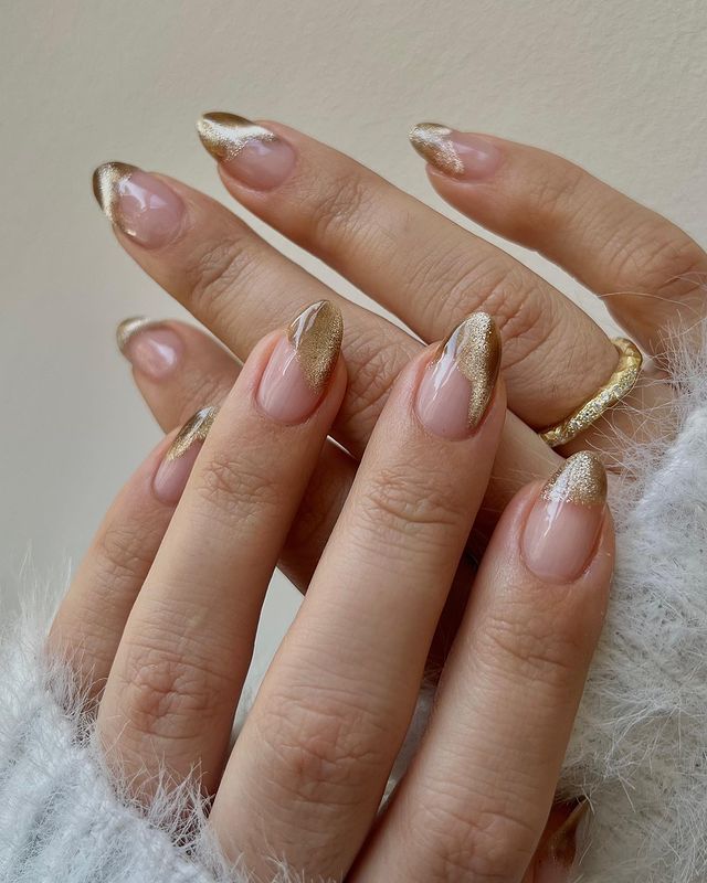 nail-art-com-esmalte-metalizado Foto de mãos com as unhas longas com nail art dourada com esmalte metalizado.