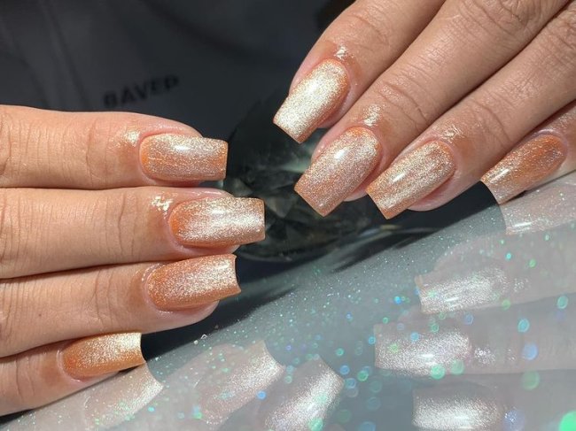 unhas-laranjas-magneticas Foto de unhas longas com esmalte laranja e esmalte magnético.
