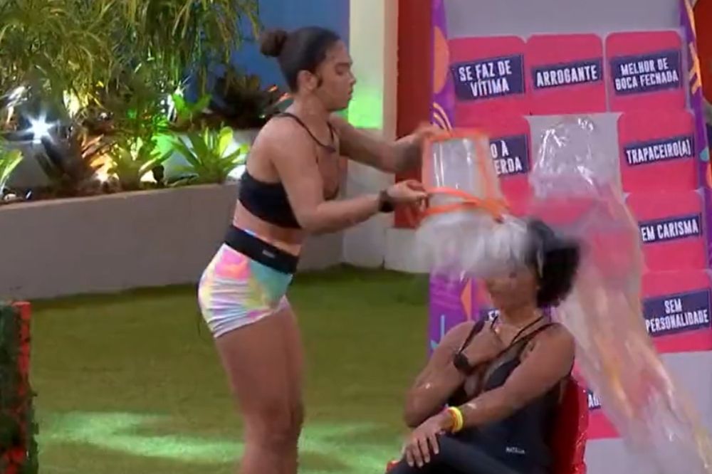 Maria jogando água e acertando o balde na cabeça de Natália no Jogo da Discórdia do BBB22