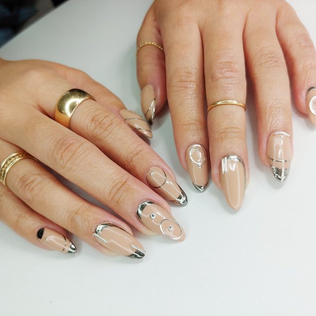 unhas-com-decoracao-metalizada Foto de unhas longas com o esmalte nude e decoração de desenhos metalizados.
