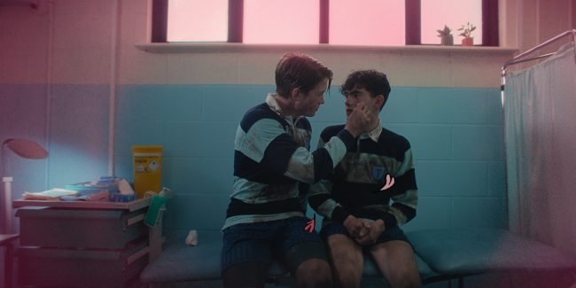 Heartstopper_Season1_Episode4_00_22_06_09 Charlie e Nick em cena de Heartstopper; os dois estão se olhando e Nick está limpando o rosto de Charlie
