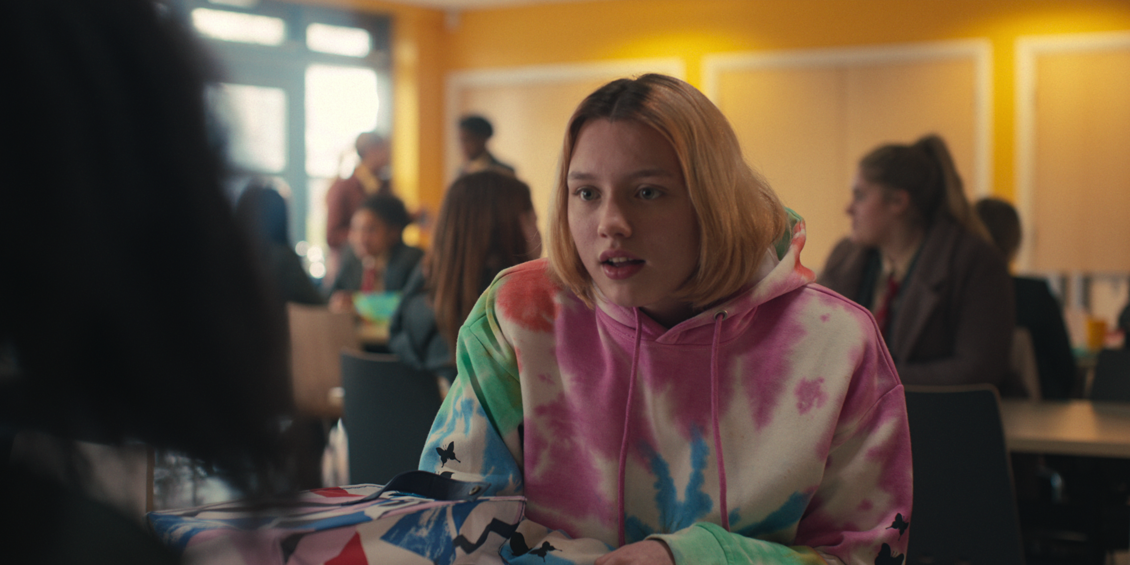 Kizzy Edgell-Darcy Olsson-heartstopper Darcy Olsson (Kizzy Edgell) em Heartstopper usando moletom tie-dye