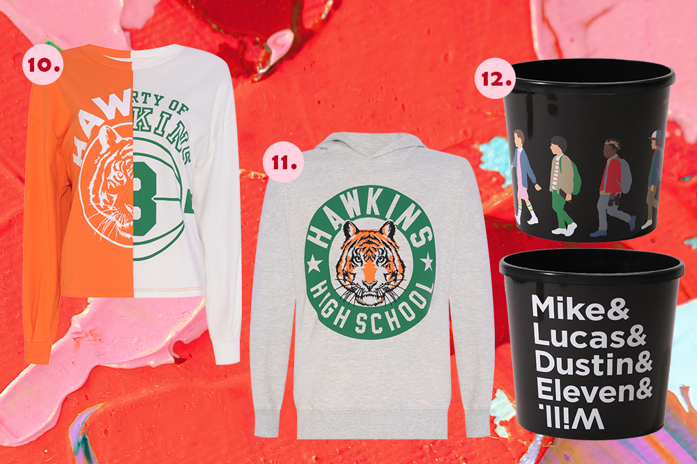 colecao-stranger-things-cea Três produtos da C&A na temática Stranger Things em montagem de fundo de tinta vermelha. Tem uma blusa cropped, um moletom e um balde de pipoca