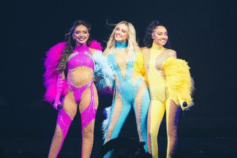 Jade, Perrie e Leigh-Anne com roupas rosa, azul e amarela em show