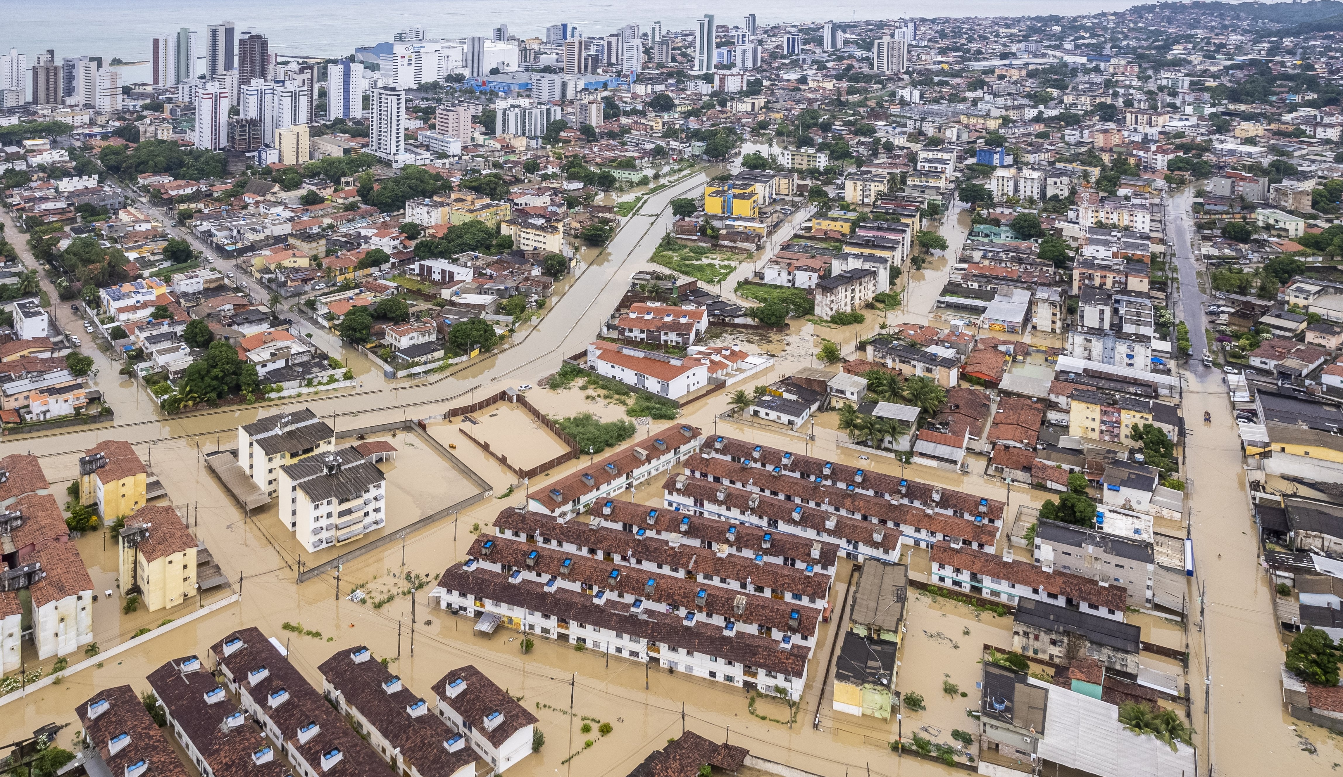 Imagem aérea de uma cidade completamente inundada por uma água lamacenta
