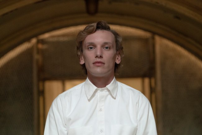 T_Gallery_01870_R (1) Jamie Campbell Bower em Stranger Things; ele usa uma roupa branca e está com a expessão séria